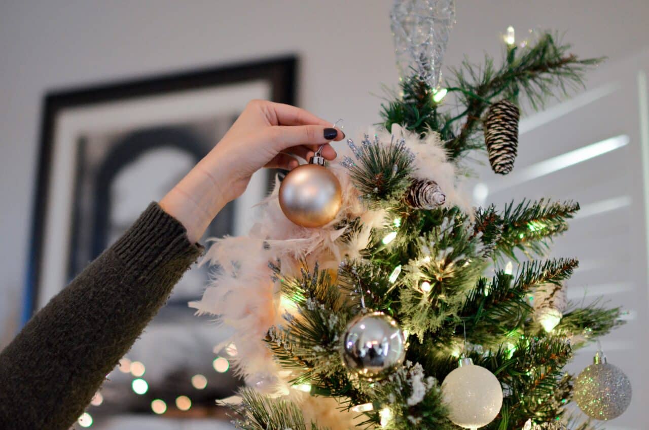 Close up of a woman decorating her Christmas tree.