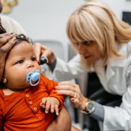 Baby gets ear examined by doctor