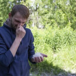 Man sneezing because of pollen in the park